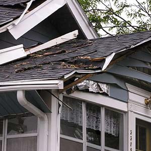 House with Storm Damage to roof and siding - click to view storm damage services